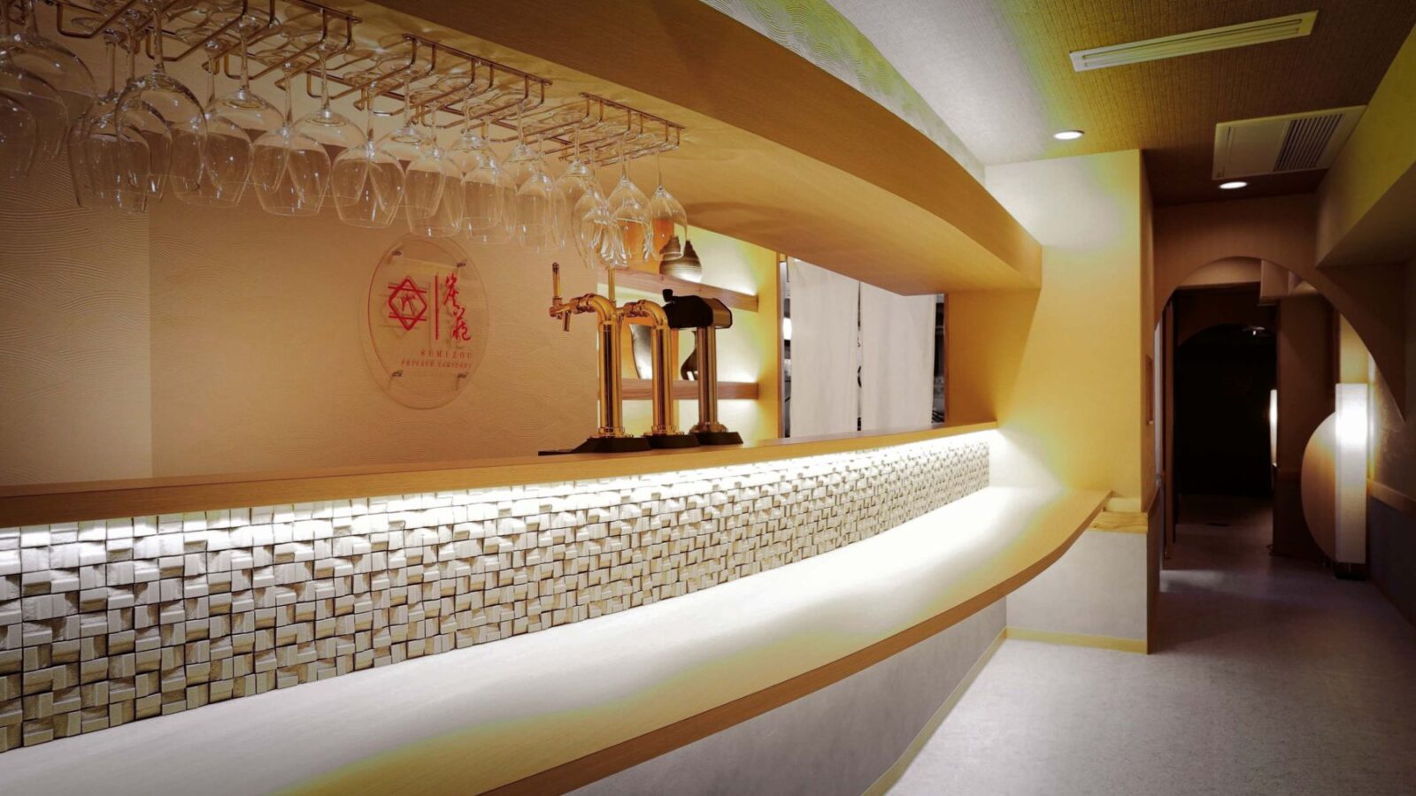 曲線のカウンターと間接照明が印象的な飲食店の店内