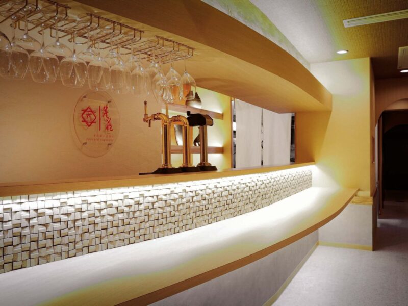 曲線のカウンターと間接照明が印象的な飲食店の店内